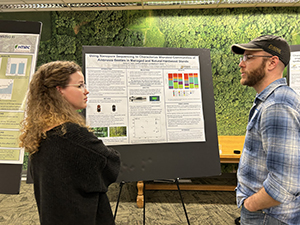 Two students discussing a poster at the annual meeting.